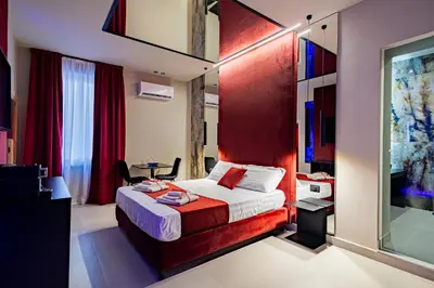 a bedroom with a bed with a red headboard at SUPREME Suite&Spa in Palermo