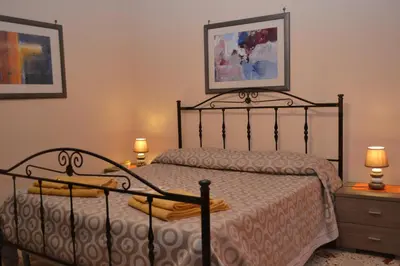 a bedroom with a bed and two night stands with lamps at B&B Jolly house Bolognetta in Bolognetta