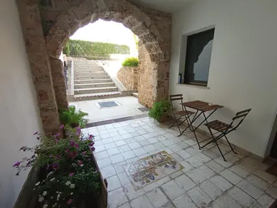 a room with an archway and a table and chairs at Casa di Lele in Carini