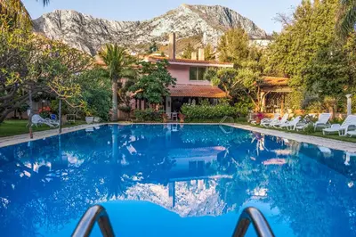 a swimming pool in front of a house with a mountain at Villa Megna - Green Paradise B&B in Sferracavallo