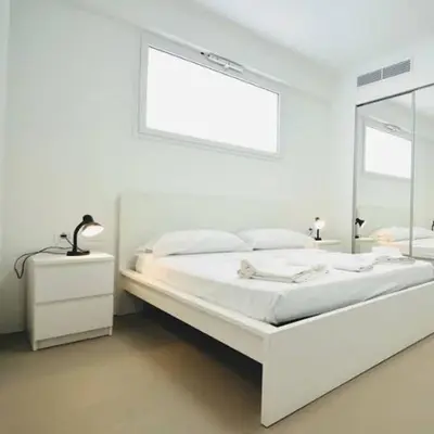 a white bedroom with a bed and a mirror at Villa Dwellings With Pool For Exclusive Use in Alcamo