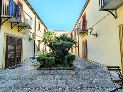 a courtyard with a palm tree in the middle of a building at Holiday Home Maya's Home Palermo by Interhome in Palermo