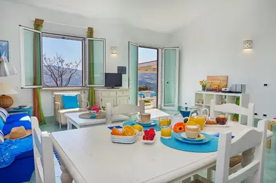 a dining room with a white table with fruit on it at Villa Sirena - Scopello-Villas in Scopello