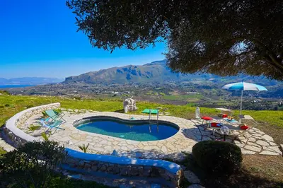 a swimming pool with a table and an umbrella at Villa Sirena - Scopello-Villas in Scopello