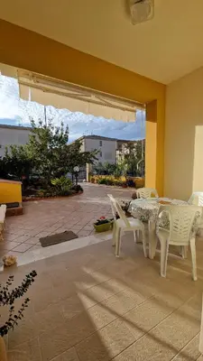 a dining room with a table and white chairs at Casa vacanza-Il Sole di Sicilia in Vita