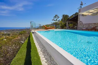 a swimming pool in front of a house at Villa del Poggio in Scopello