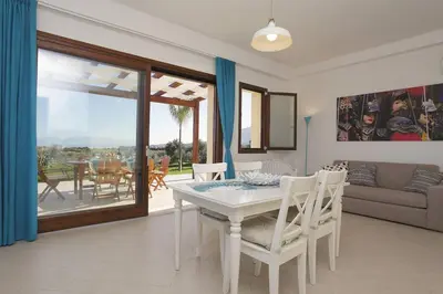 a living room with a white table and chairs at Villa delle Stelle in Scopello