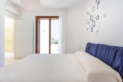 a bedroom with a bed and a blue couch at Villa delle Stelle in Scopello