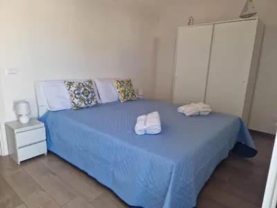 a bedroom with a blue bed with two towels on it at Il Cavaliere Apartment in Capaci