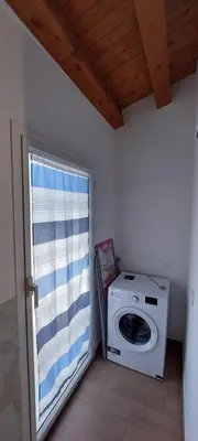 a washing machine in a room with a window at Il Cavaliere Apartment in Capaci