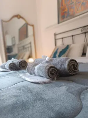 two rolled towels sitting on top of a bed at Metro 171 Loft in Palermo