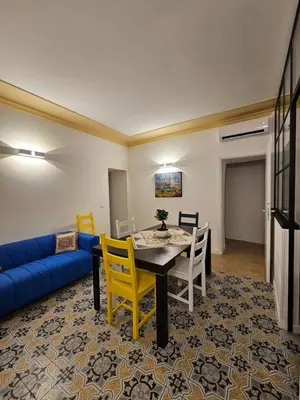 a living room with a table and a blue couch at Casa Novelli 22 - Vista sulla Cattedrale in Palermo