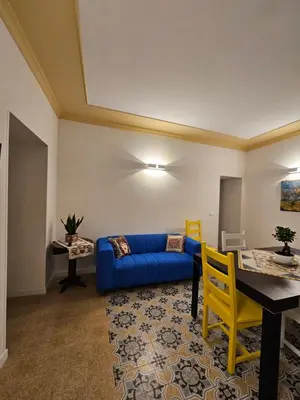 a living room with a blue couch and a table at Casa Novelli 22 - Vista sulla Cattedrale in Palermo