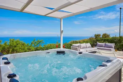 a hot tub with a view of the ocean at Villa del Drago in Scopello