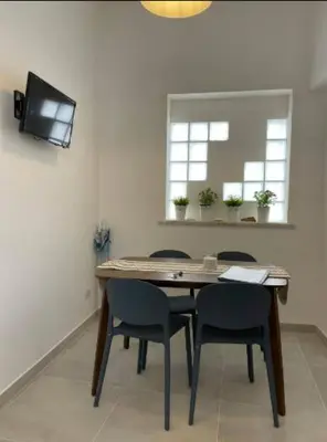 a table with chairs and a television in a room at Coralìa in San Vito lo Capo