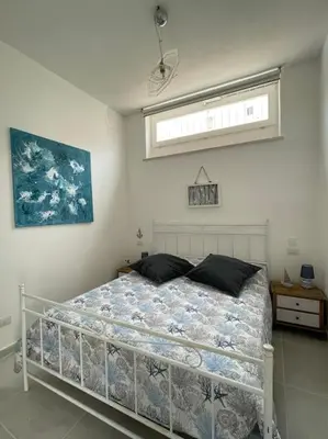 a bedroom with a bed in a room with a window at Coralìa in San Vito lo Capo