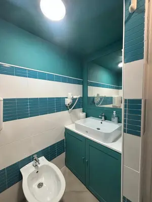 a blue and white bathroom with a sink and a mirror at Appartamento San Vito in Piana degli Albanesi