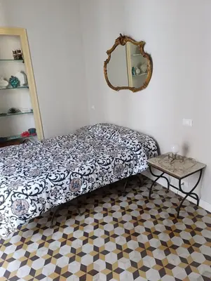 a bedroom with a bed and a mirror and a table at La dimora del MARCHESE NOTARBARTOLO in Palermo
