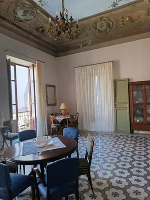a living room with a table and chairs at La dimora del MARCHESE NOTARBARTOLO in Palermo