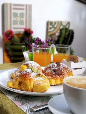 a plate of pastries on a table with a cup of coffee at PalermiT'Amo in Palermo
