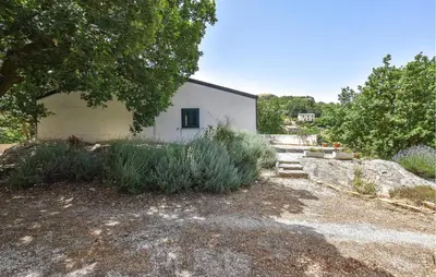 a white building with a tree and some bushes at Pet Friendly Home In Corleone With Wifi in Corleone