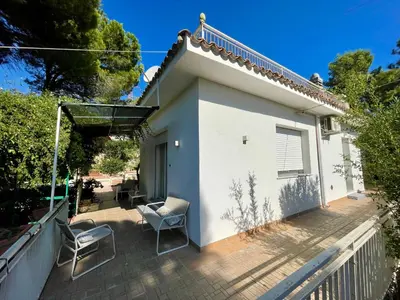 a patio with two chairs and a house at Splendida Villa immersa nella natura - Villa Salina Trabia in Trabia