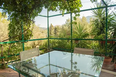a glass table and chairs on a patio with a view at Splendida Villa immersa nella natura - Villa Salina Trabia in Trabia