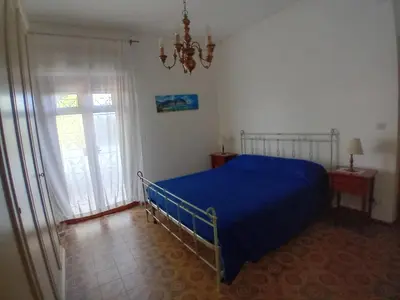 a bedroom with a blue bed and a window at ai colori di Giggia in Isola delle Femmine