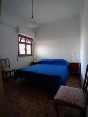 a bedroom with a blue bed and a window at ai colori di Giggia in Isola delle Femmine