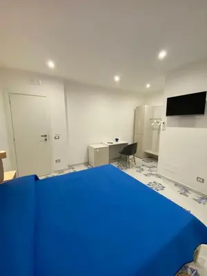 a room with a blue bed and a desk at Casa Vacanze dell'Arco - civico 17 in Trabia