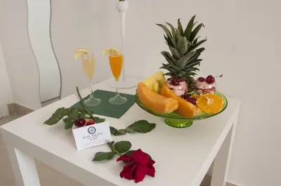 a table with a bowl of fruit and two glasses of champagne at Due Passi in Palermo