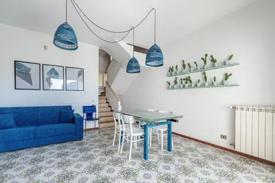 a living room with a blue couch and a table at Hola House Mondello in Lido di Mondello