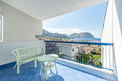 a balcony with a table and chairs and a view at Hola House Mondello in Lido di Mondello