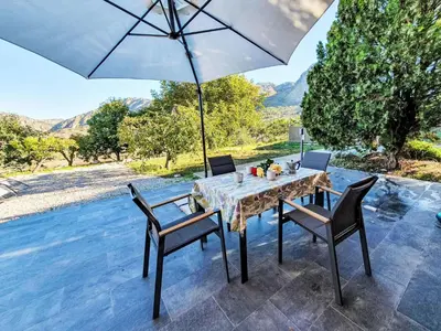 a table and chairs with an umbrella on a patio at Villa Ginestra by Interhome in Piana degli Albanesi