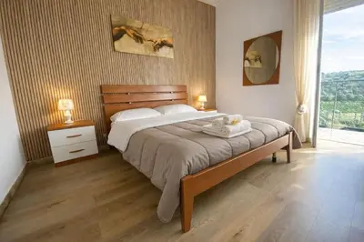 a bedroom with a bed with two lamps and a window at Nichi & Matti Iemmolo's Guest House in Campofelice di Roccella