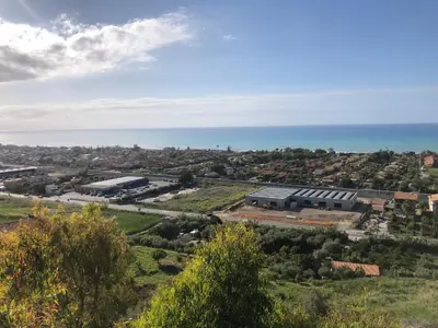 an aerial view of a building with the ocean in the background at Nichi & Matti Iemmolo's Guest House in Campofelice di Roccella