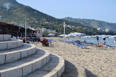 a beach with chairs and umbrellas and the ocean at Nichi & Matti Iemmolo's Guest House in Campofelice di Roccella