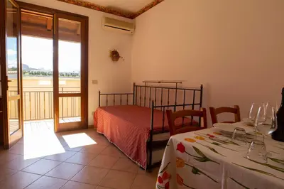 a bedroom with a bed and two tables and a balcony at Residence Hotel Marino Tourist in San Vito lo Capo