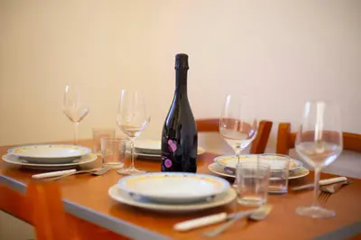 a table with glasses and a bottle of wine at Residence Hotel Marino Tourist in San Vito lo Capo