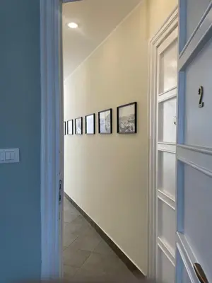 a hallway with four photos on the wall and a door at La Terrazza su Palermo in Palermo