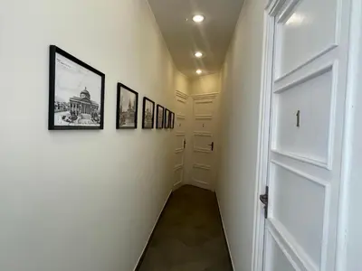 a hallway with a white door and pictures on the walls at La Terrazza su Palermo in Palermo