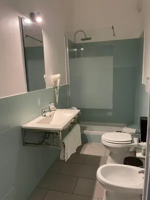 a bathroom with a sink and a toilet and a mirror at La Terrazza su Palermo in Palermo
