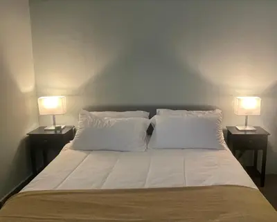 a bed with two white pillows and two lamps at La Terrazza su Palermo in Palermo