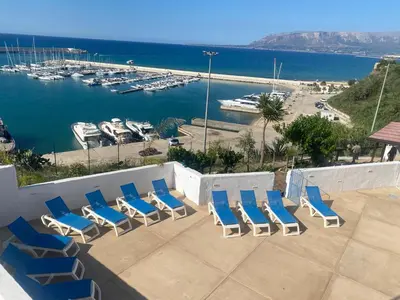 a group of chairs sitting on a patio with a marina at Loft Sul Mare in Balestrate