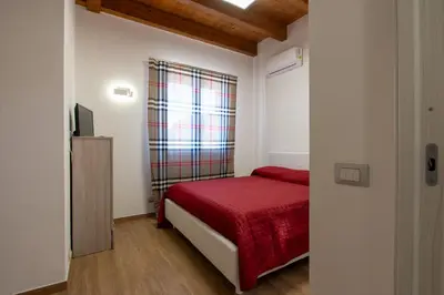 a small bedroom with a red bed and a television at Villa Ginevra in Santa Ninfa