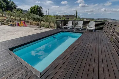 a swimming pool on a wooden deck with chairs around it at Villa Ginevra in Santa Ninfa
