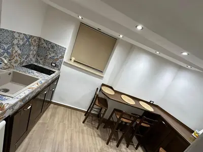 a kitchen with a table and chairs in a room at Lucky House in Palermo