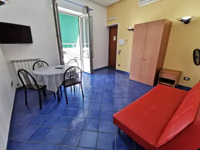 a living room with a red couch and a table at Appartamento Tirreno Mondello in Palermo