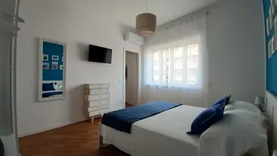 a bedroom with a bed with blue pillows and a window at Al Duca appartamento in centro in Palermo
