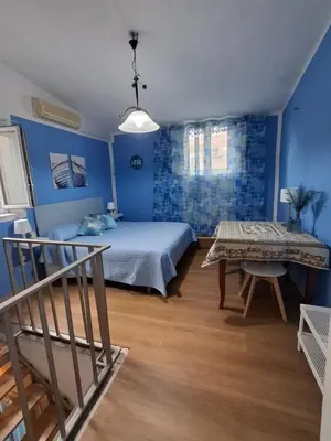 a bedroom with blue walls and a bed and a table at La Casa di Giovy in Palermo